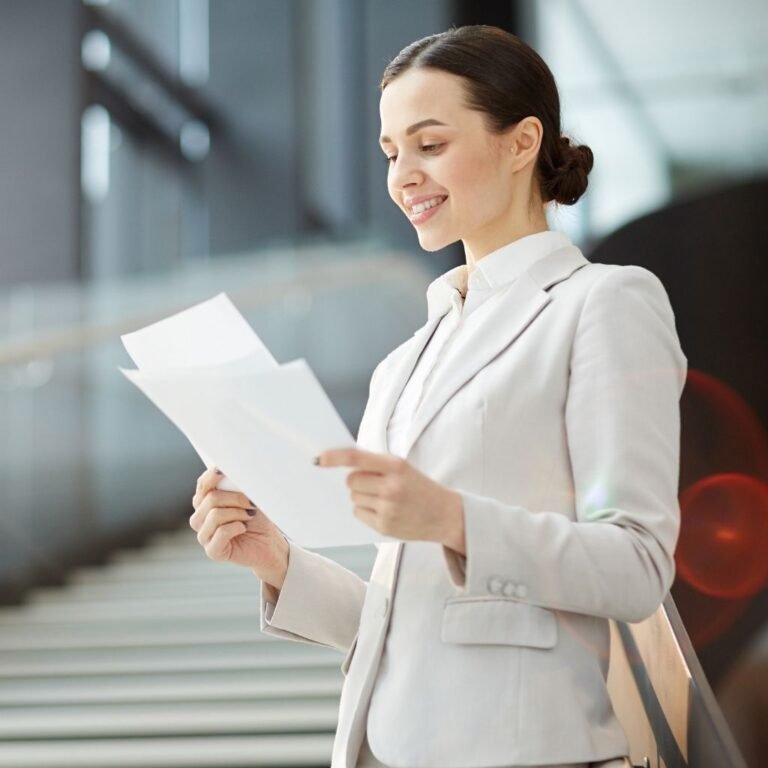 Mujer de unos 30 años leyendo con atención los documentos de su póliza de seguro en una mesa con luz natural, simbolizando la importancia de comprender las condiciones del contrato de Vida Mujer.
